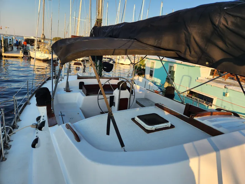 Slide: The Image of 1979 Morgan 45 Ketch sailboat docked at marina, featuring spacious deck and covered cockpit. - 26