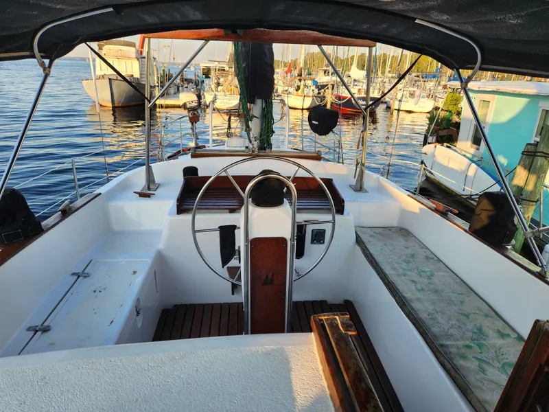 Slide: The Image of 1979 Morgan 45 Ketch sailboat cockpit with steering wheel, docked at marina. - 29