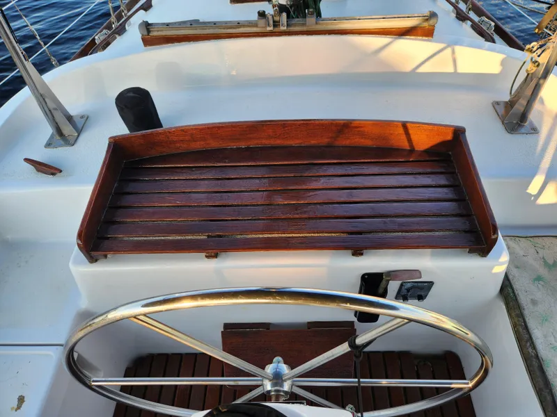 Slide: The Image of 1979 Morgan 45 Ketch sailboat cockpit with wooden seating and steering wheel. - 34