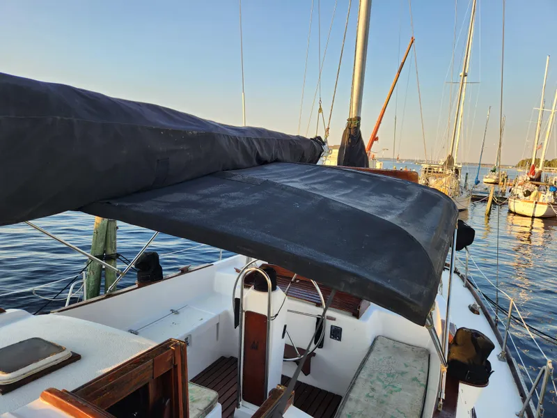 Slide: The Image of 1979 Morgan 45 Ketch sailboat with covered cockpit, docked in a marina. - 35