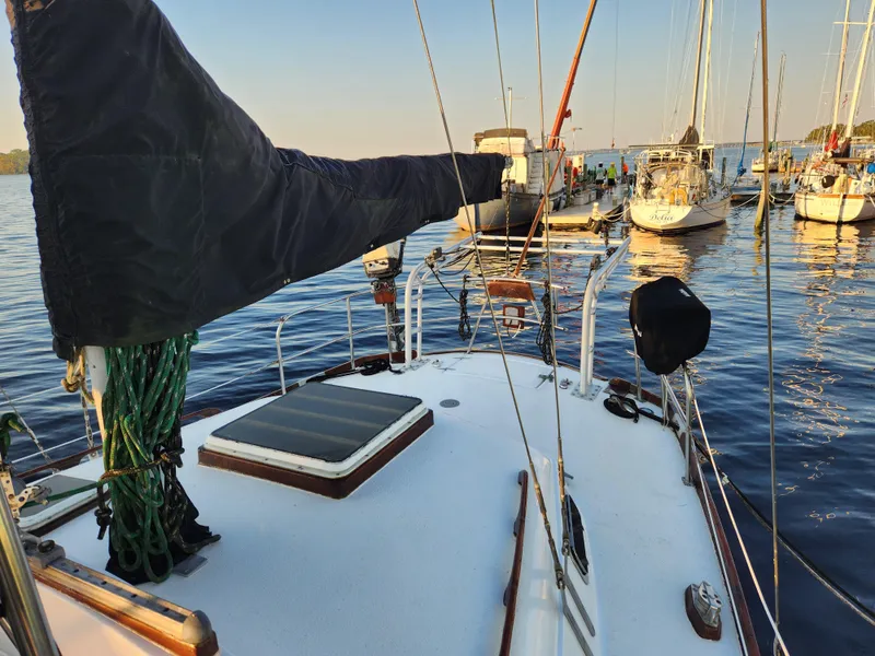 Slide: The Image of 1979 Morgan 45 Ketch sailboat docked in a serene marina setting. - 40