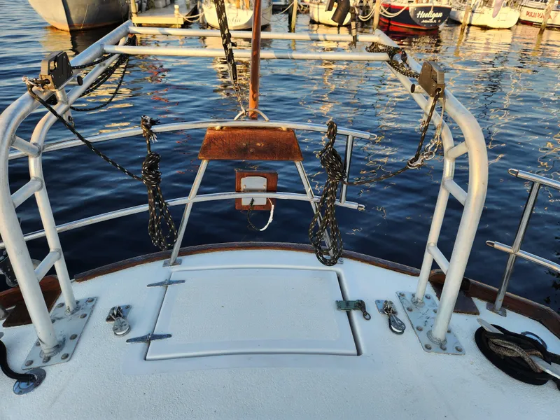 Slide: The Image of 1979 Morgan 45 Ketch sailboat deck with railing and mooring lines at marina. - 41