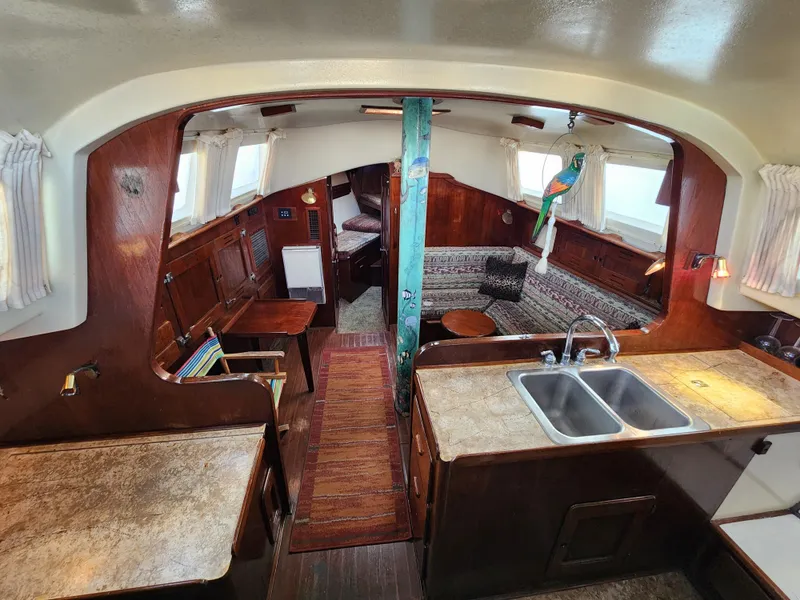 Slide: The Image of Interior of 1979 Morgan 45 Ketch sailboat, featuring cozy wood finishes and a compact kitchen area. - 45