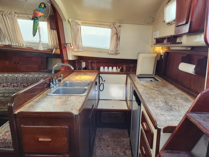 Slide: The Image of Interior of 1979 Morgan 45 Ketch sailboat kitchen with wooden cabinetry and dual sinks. - 48
