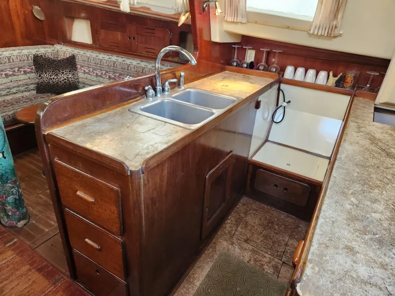 Slide: The Image of 1979 Morgan 45 Ketch interior with wooden cabinetry and kitchen sink. - 49