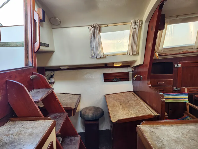 Slide: The Image of Interior of a 1979 Morgan 45 Ketch sailboat with wooden furnishings and seating. - 51