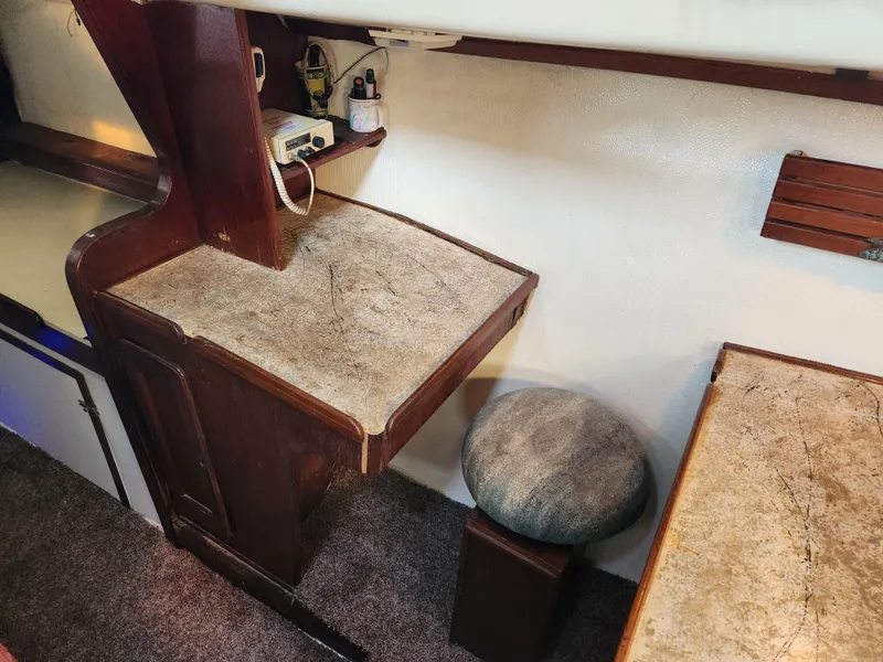 Slide: The Image of 1979 Morgan 45 Ketch interior with wooden desk and stool, showcasing vintage nautical design. - 53