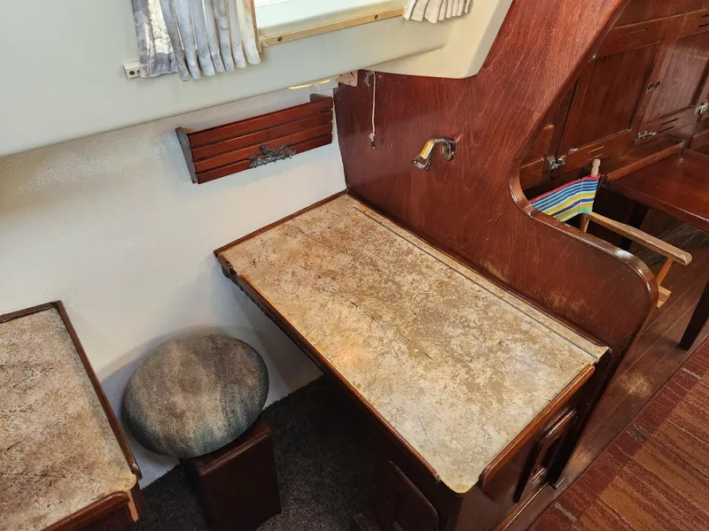 Slide: The Image of Interior of a 1979 Morgan 45 Ketch, featuring a wooden desk and stool. - 54