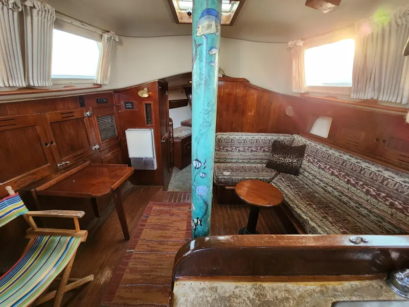 Slide: The Image of Interior of 1979 Morgan 45 Ketch sailboat with wooden furnishings and cozy seating area. - 55