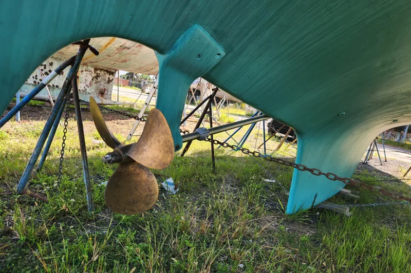 Slide: The Image of 1979 Morgan 45 Ketch sailboat hull and propeller on stands, grassy yard. - 8