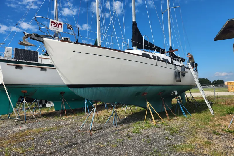 Slide: The Image of 1979 Morgan 45 Ketch sailboat on stands, for sale, under clear blue sky. - 9