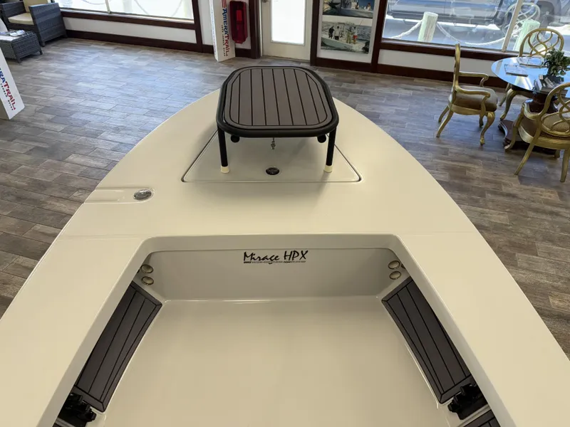 Slide: The Image of 2025 Maverick 18 HPX-V boat interior with seating and table in showroom. - 20