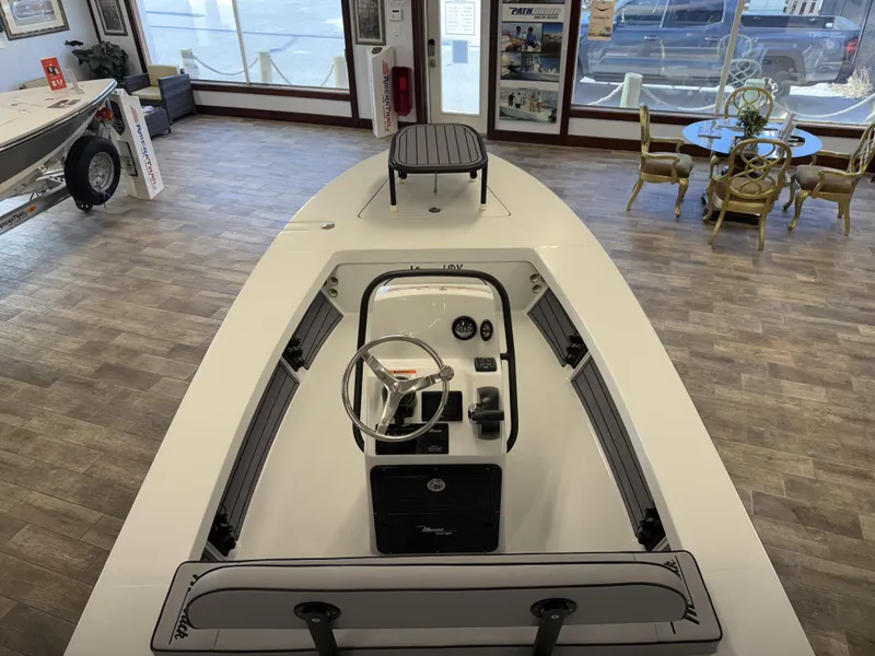 Slide: The Image of 2025 Maverick 18 HPX-V boat interior in showroom, featuring steering console and seating. - 7