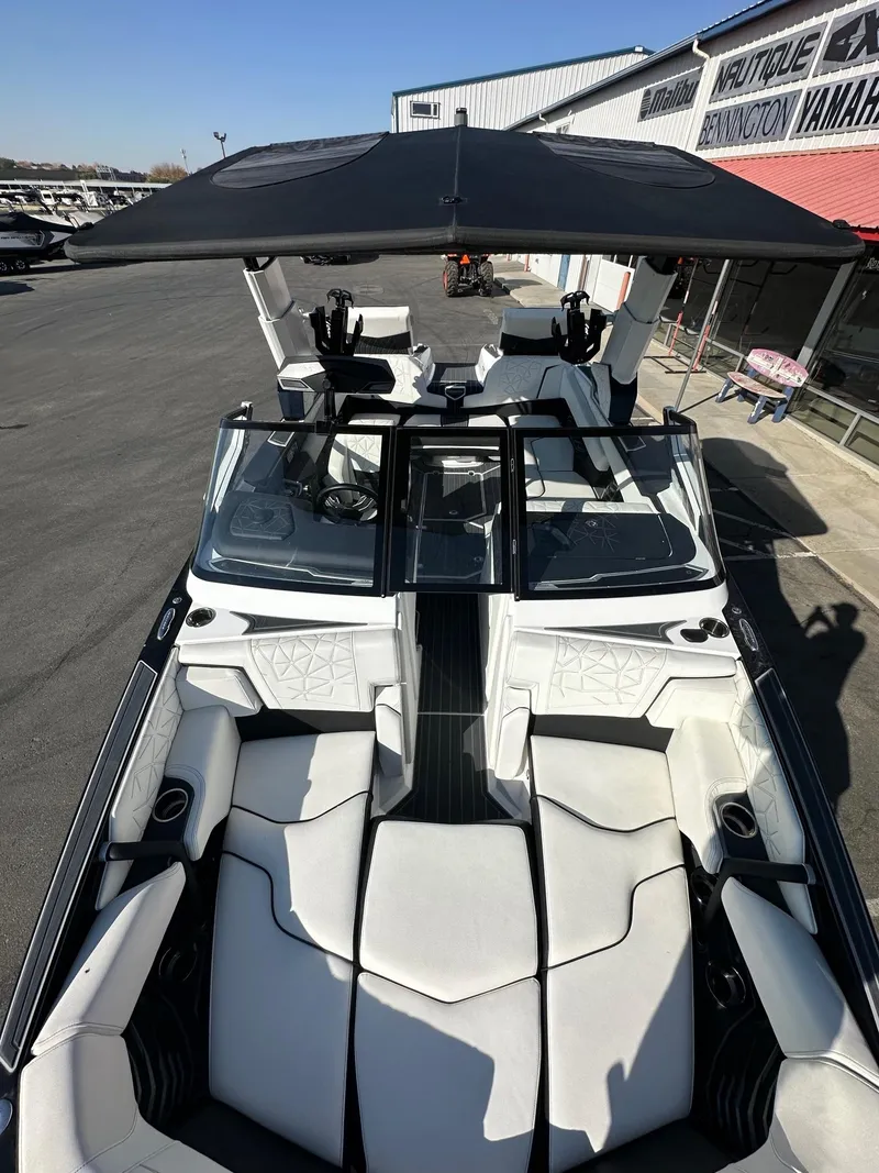 Slide: The Image of 2023 Nautique PARAGON 23 boat with luxurious seating and sleek design at a dealership. - 13