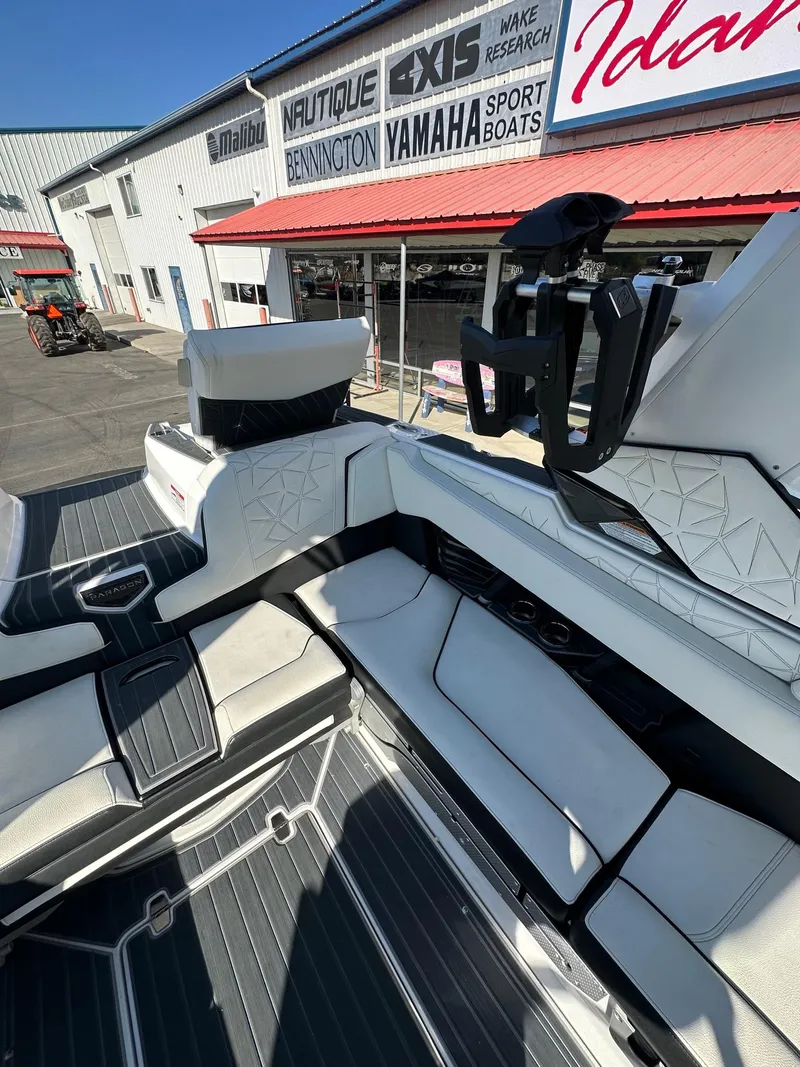 Slide: The Image of 2023 Nautique PARAGON 23 interior with sleek seating, displayed at a boat dealership. - 16