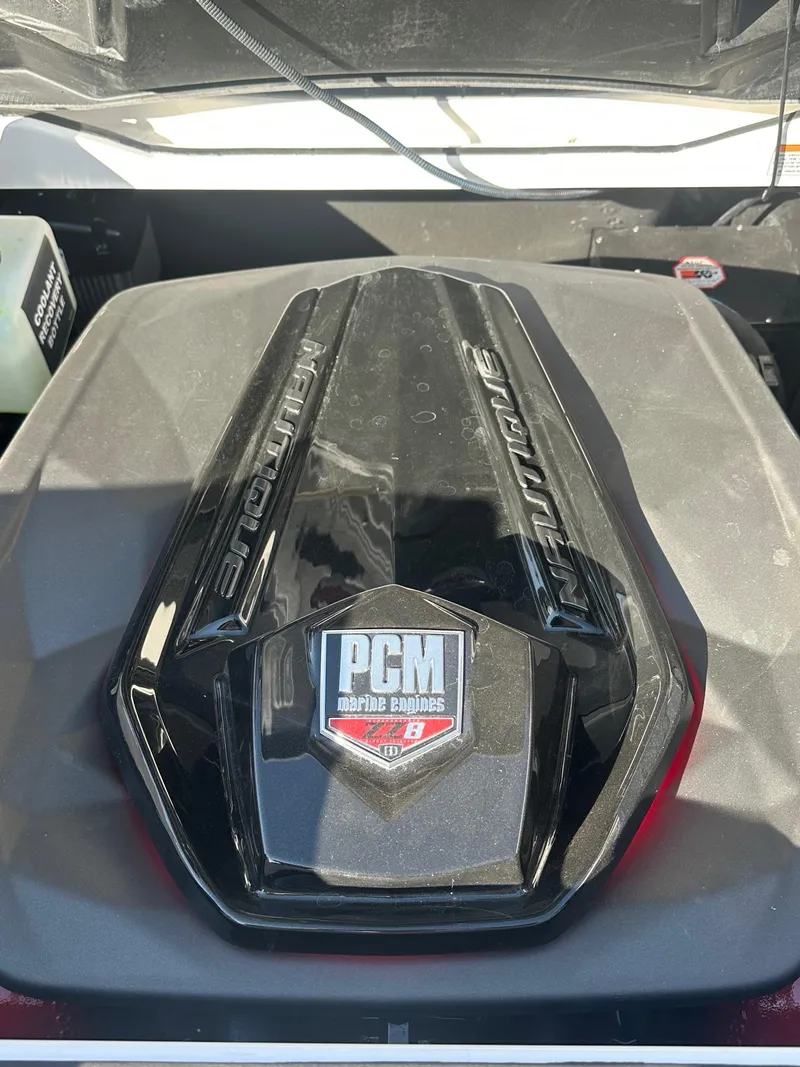 Slide: The Image of 2023 Nautique PARAGON 23 engine cover with PCM branding. - 21
