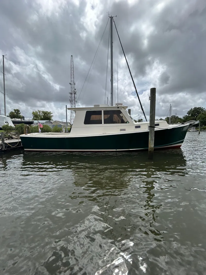 Slide: The Image of 1996 Mast & Mallet 34 Rabbit Custom boat docked under cloudy skies. - 1