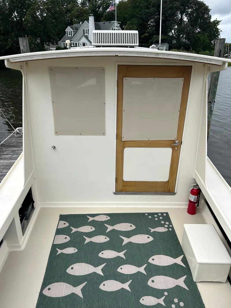 Slide: The Image of 1996 Mast & Mallet 34 Rabbit Custom boat deck with fish-patterned rug and wooden door. - 10