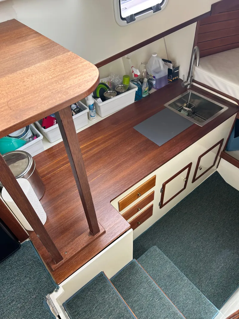 Slide: The Image of Interior of 1996 Mast & Mallet 34 Rabbit Custom boat with wooden countertops and compact kitchen area. - 19