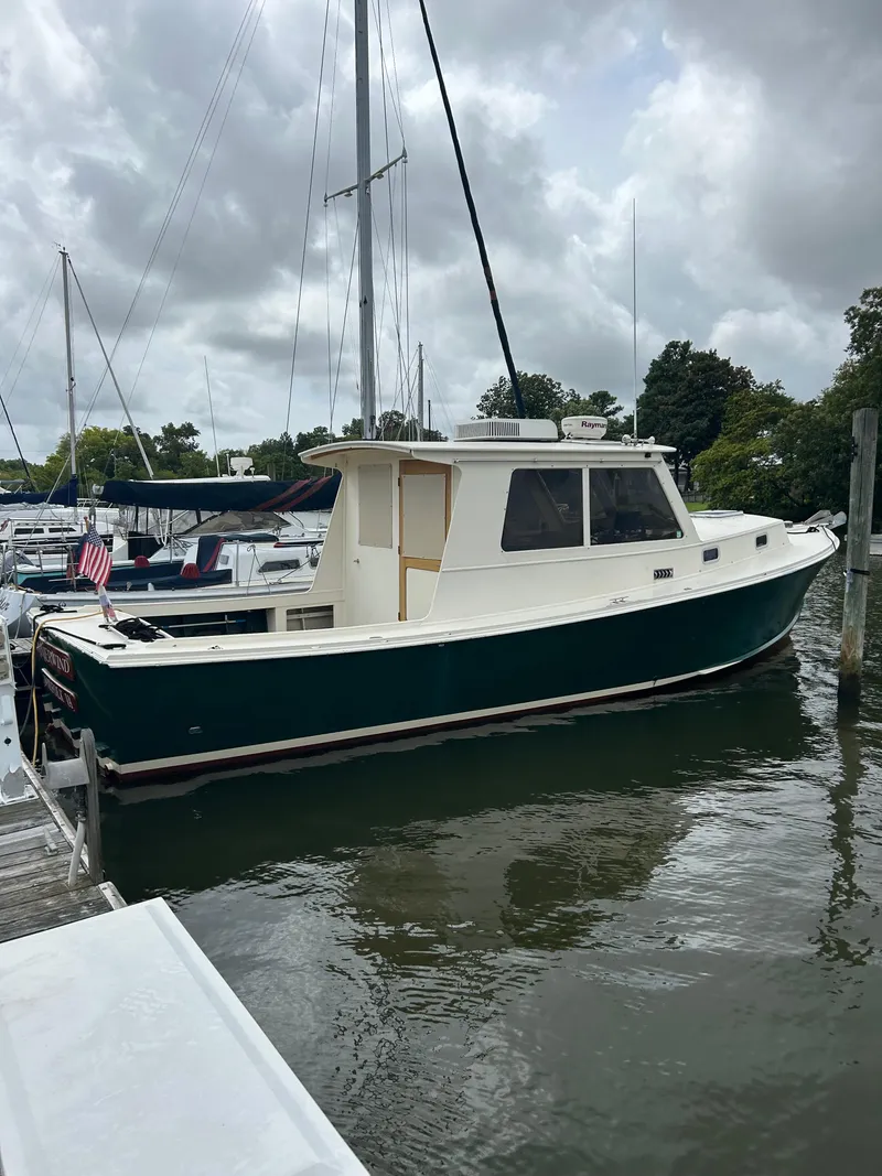 Slide: The Image of 1996 Mast & Mallet 34 Rabbit Custom boat docked in a marina under cloudy skies. - 2