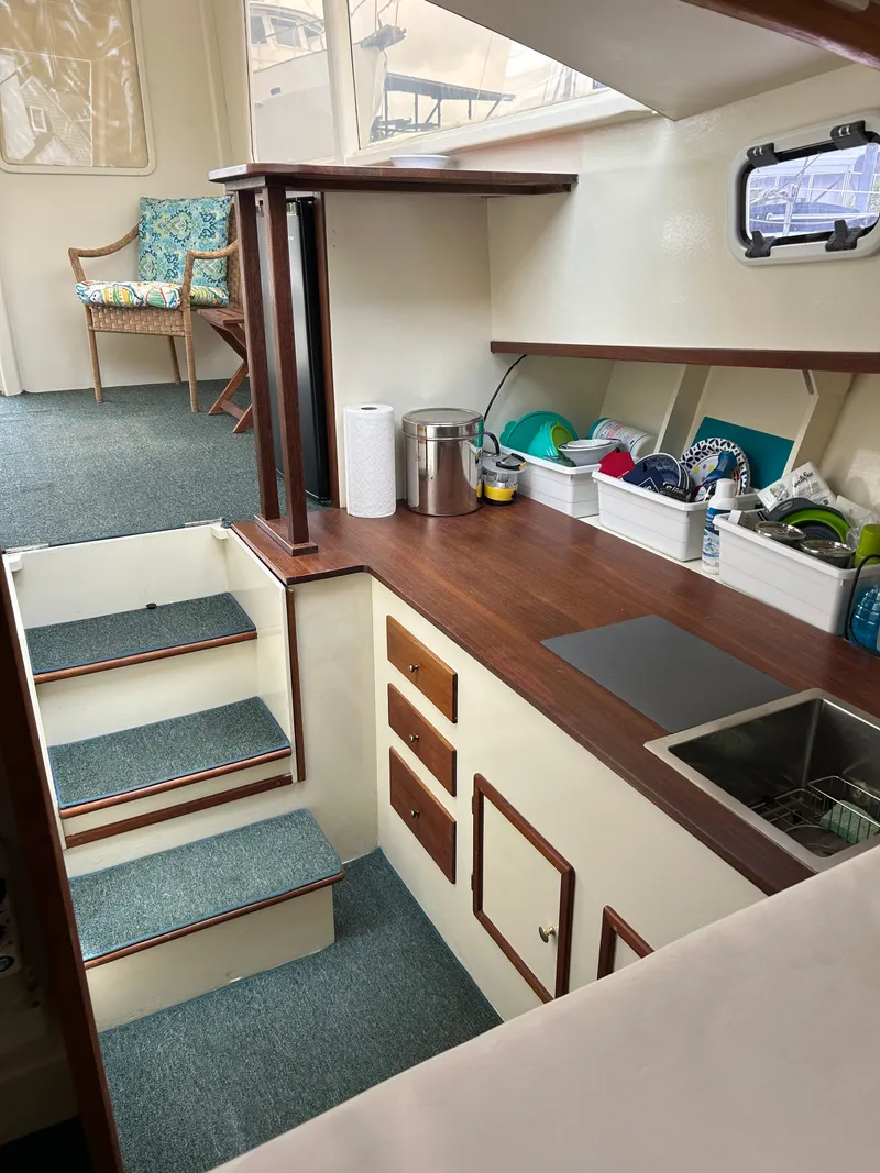 Slide: The Image of Interior of 1996 Mast & Mallet 34 Rabbit Custom boat with compact kitchen and seating area. - 24