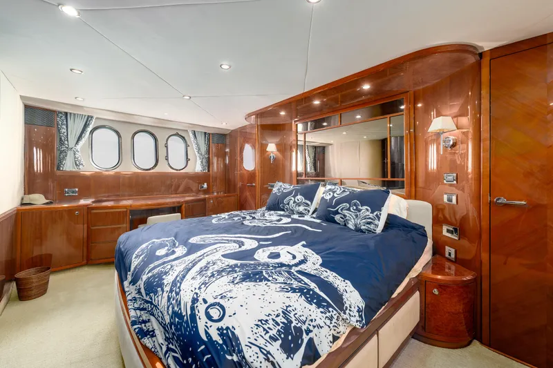 Slide: The Image of Luxurious 2008 Viking Princess 75 yacht bedroom with elegant wood paneling and nautical-themed bedding. - 11