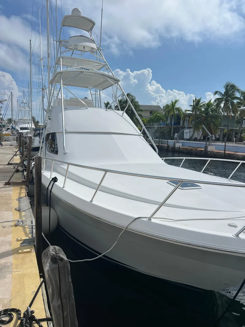 Slide: The Image of 2005 Rampage 45 Convertible yacht docked at marina under blue sky. - 1