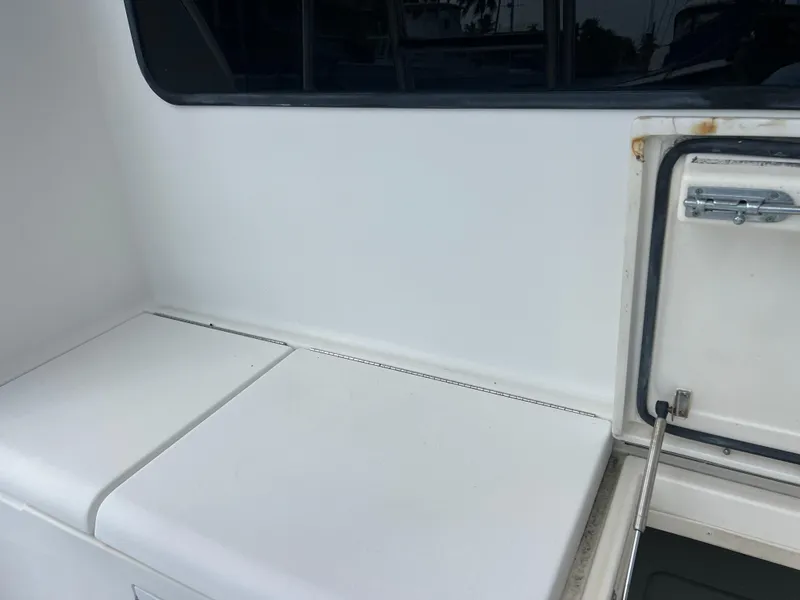 Slide: The Image of 2005 Rampage 45 Convertible boat interior with white seating and storage compartment. - 14