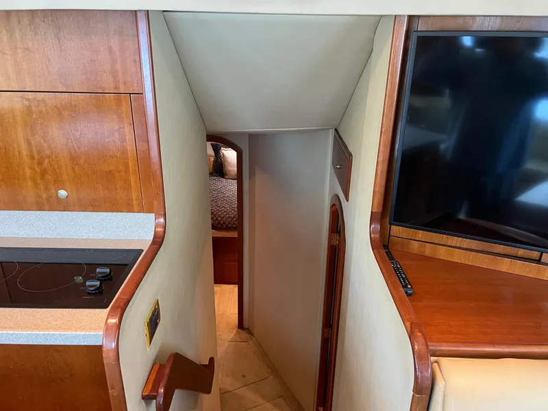 Slide: The Image of Interior of 2005 Rampage 45 Convertible yacht with stairs, TV, and wood cabinetry. - 26