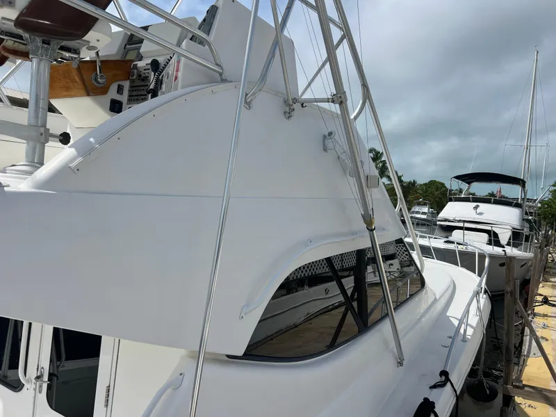 Slide: The Image of 2005 Rampage 45 Convertible yacht docked at marina, featuring sleek white design. - 3