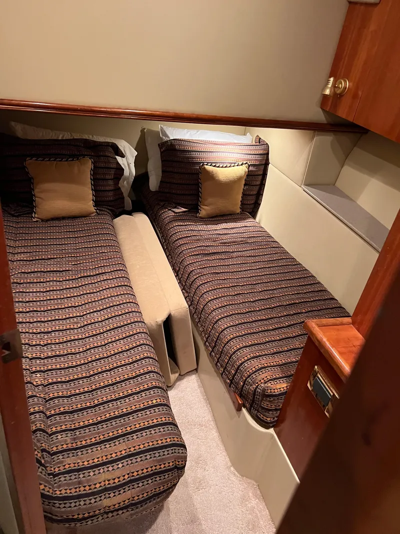 Slide: The Image of 2005 Rampage 45 Convertible cabin with twin beds and striped bedding. - 32