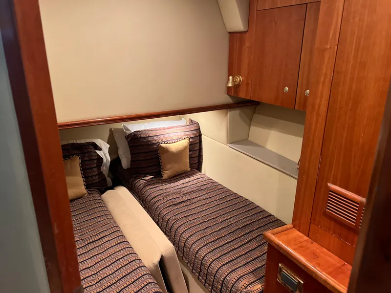 Slide: The Image of 2005 Rampage 45 Convertible cabin with twin beds and wooden cabinetry. - 33