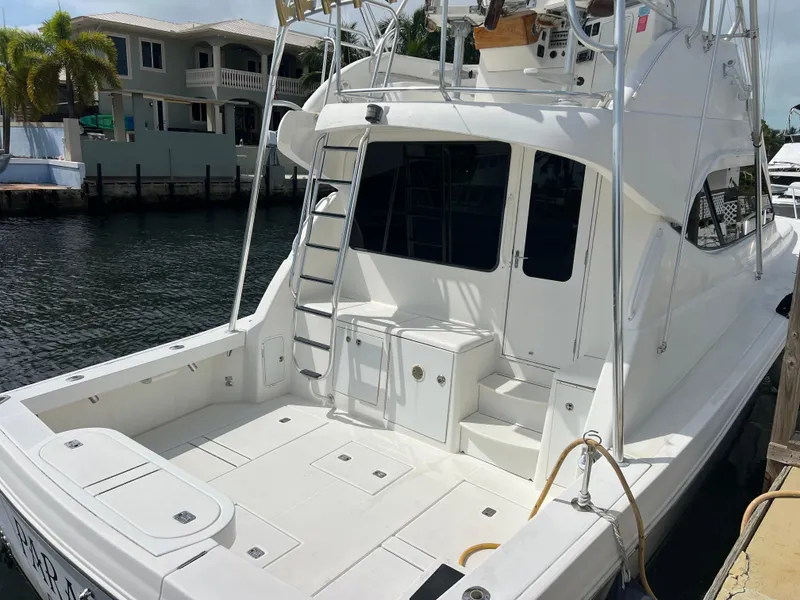 Slide: The Image of 2005 Rampage 45 Convertible yacht docked by waterfront homes. - 4