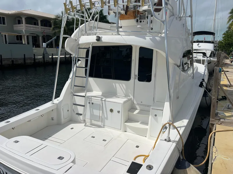 Slide: The Image of 2005 Rampage 45 Convertible yacht docked by waterfront homes. - 5