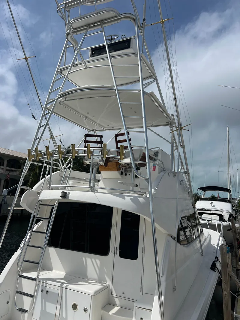 Slide: The Image of 2005 Rampage 45 Convertible yacht with tower, docked under cloudy skies. - 7