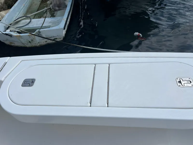 Slide: The Image of 2005 Rampage 45 Convertible boat deck with storage compartment, docked near water. - 9