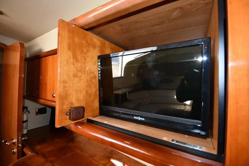 Slide: The Image of 1997 Sunseeker Camargue 47 interior with built-in TV and wooden cabinetry. - 56