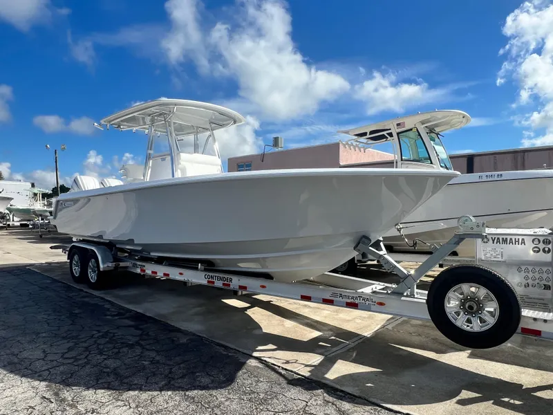Slide: The Image of 2025 Contender 30 ST boat on trailer under clear blue sky. - 1