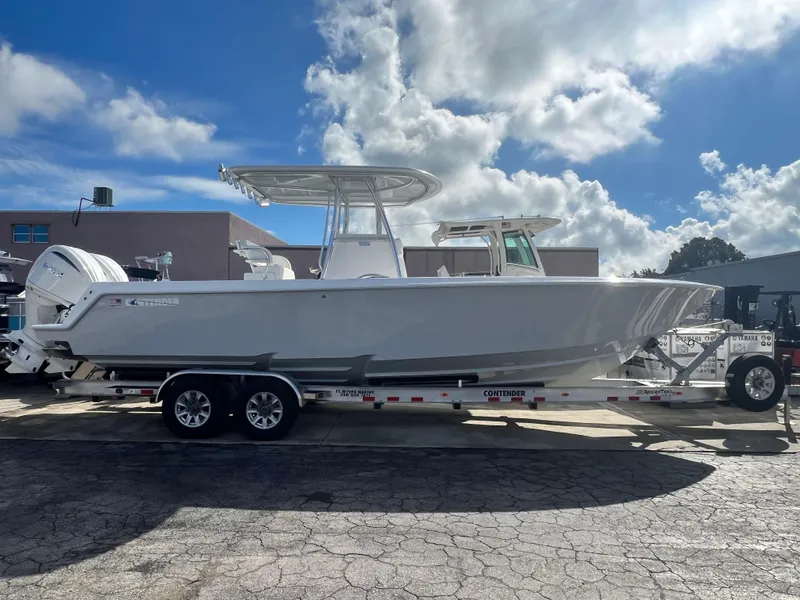 Slide: The Image of 2025 Contender 30 ST boat on trailer under a cloudy sky. - 2