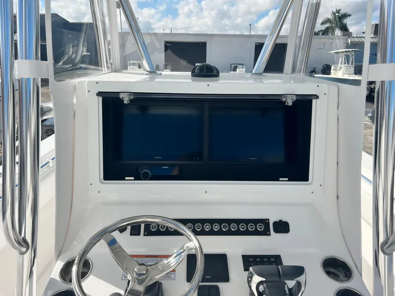 Slide: The Image of 2025 Contender 30 ST boat dashboard with dual screens and steering wheel. - 6