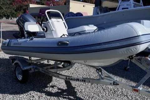 The Image of 2025 Highfield Classic 380 GT boat on Load Rite trailer, parked on gravel. - 0