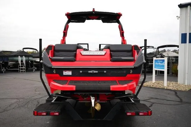 Slide: The Image of 2025 Supra SA 450 boat, rear view, vibrant red color, parked outdoors. - 5