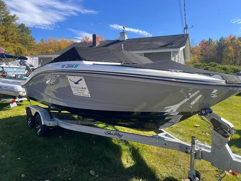 The Image of 2023 Sea Ray SPX 190 boat on trailer, parked outdoors under clear sky. - 1