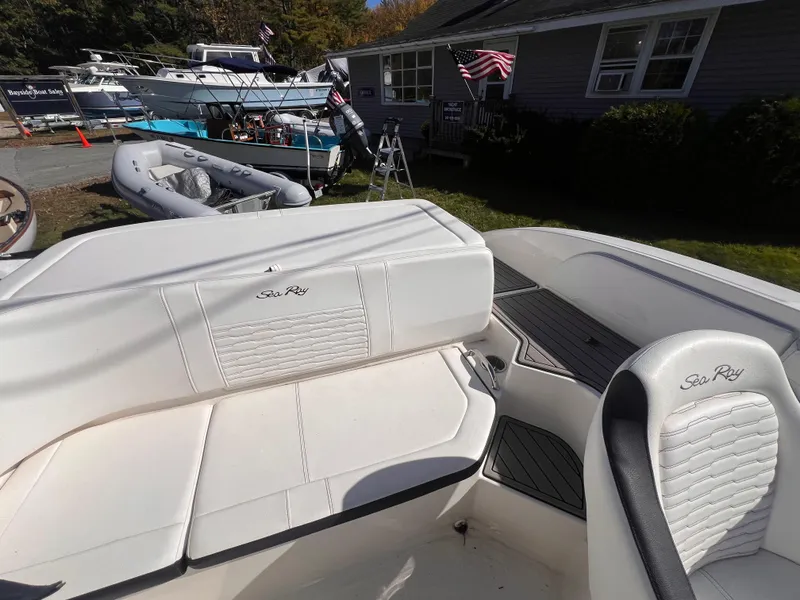 Slide: The Image of 2023 Sea Ray SPX 190 boat interior with white seating and outdoor setting. - 13