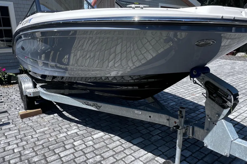Slide: The Image of 2023 Sea Ray SPX 190 boat on trailer, parked on cobblestone driveway. - 29