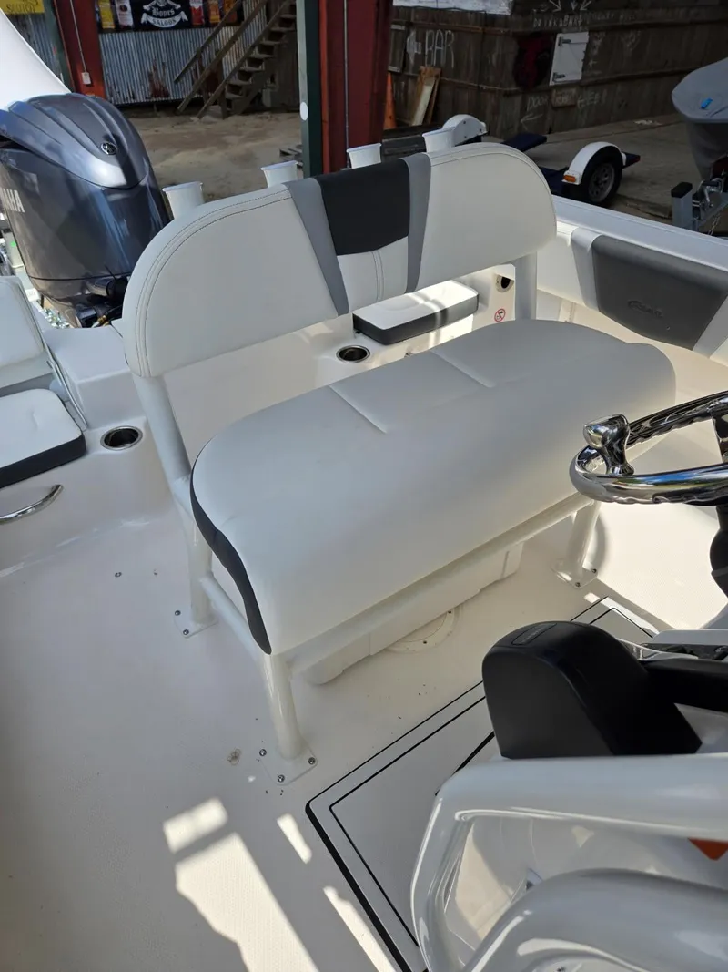 Slide: The Image of 2025 Robalo R180 Center Console boat interior with white seating and steering wheel. - 11