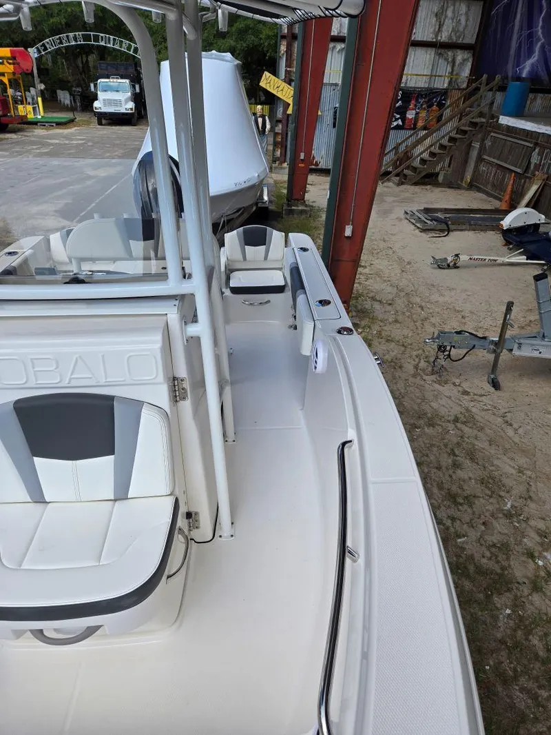 Slide: The Image of 2025 Robalo R180 Center Console boat, white interior, docked in a marina. - 18