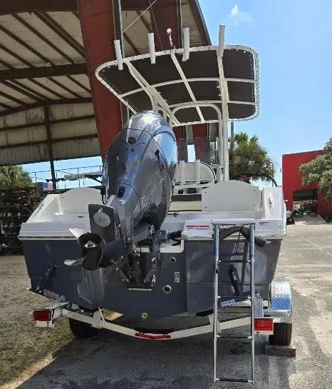 Slide: The Image of 2025 Robalo R180 Center Console boat with outboard motor and ladder, parked outdoors. - 2