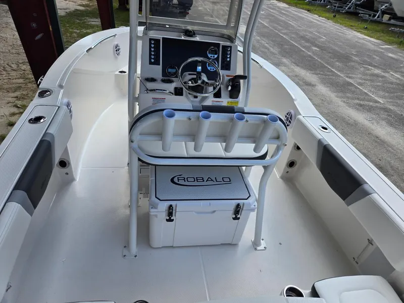 Slide: The Image of 2025 Robalo R180 Center Console boat interior with steering wheel and rod holders. - 22