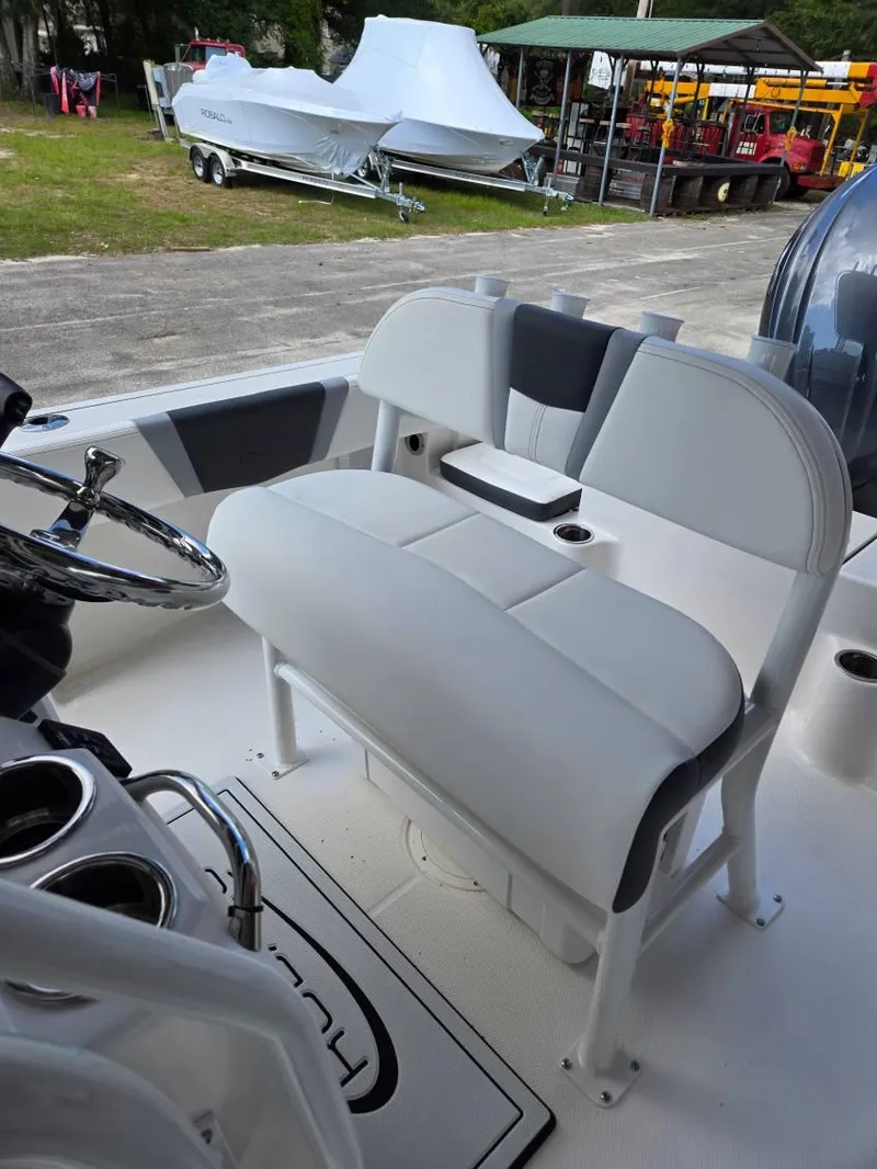 Slide: The Image of 2025 Robalo R180 Center Console boat interior with cushioned seating and steering wheel. - 24